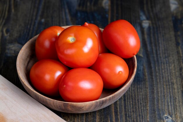 Ganze frische Tomaten in einer Holzschale