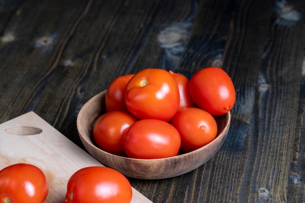 Ganze frische Tomaten in einer Holzschale