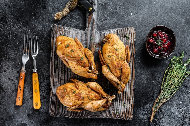 Ganze gegrillte Wachteln auf einem hölzernen Schneidebrett