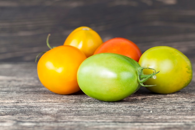 Ganze grüne rote und gelbe Tomaten auf einem alten Küchentisch