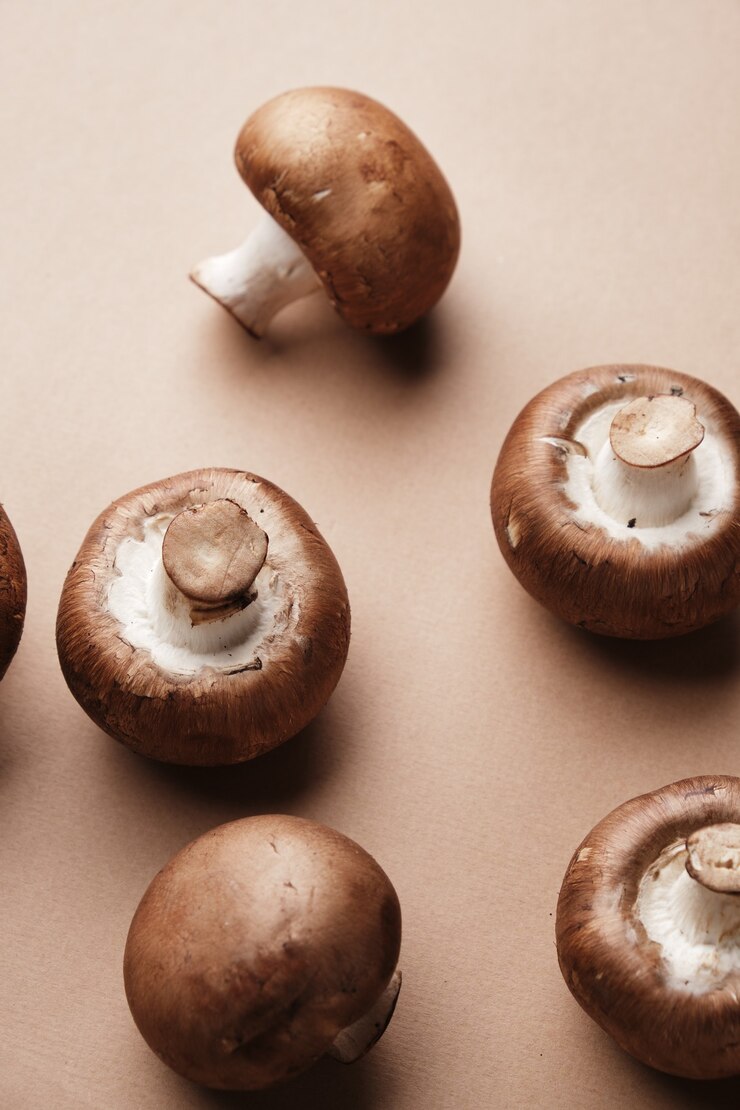 Foto ganze königsbraune champignons auf braunem hintergrund