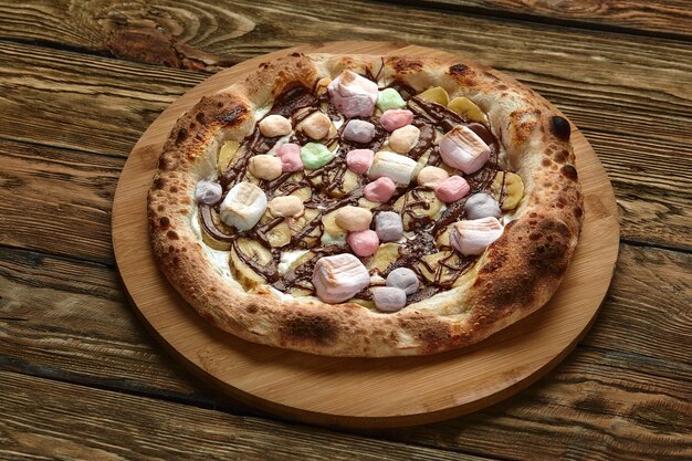 Ganze süße Pizza serviert mit Marshmallows und Süßigkeiten