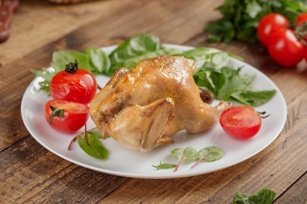 Ganzes gebratenes Hähnchen mit gegrillten Tomaten