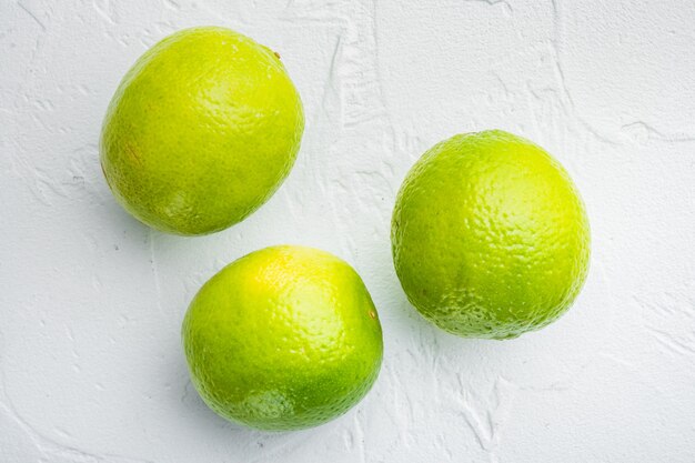 Ganzes grünes Limettenset, auf weißem Tisch, Draufsicht oder flacher Lage