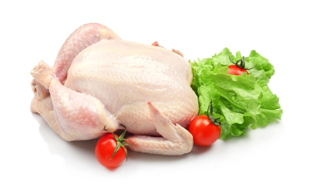 Ganzes rohes Huhn mit Salat und Tomaten auf weißem Hintergrund