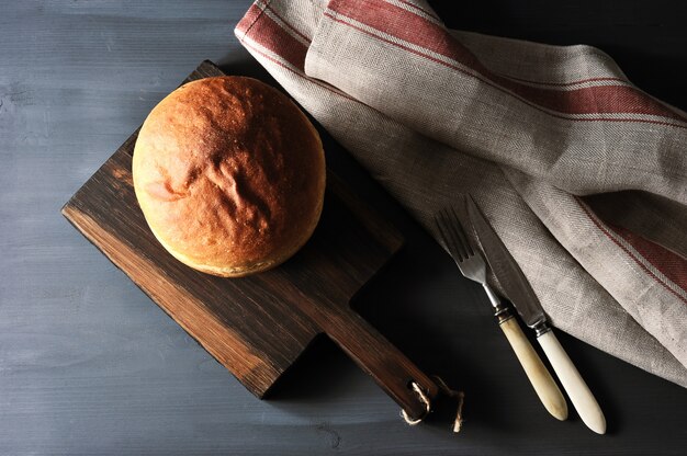 Ganzes Weißbrot mit einer runden Form auf einem hölzernen Brett