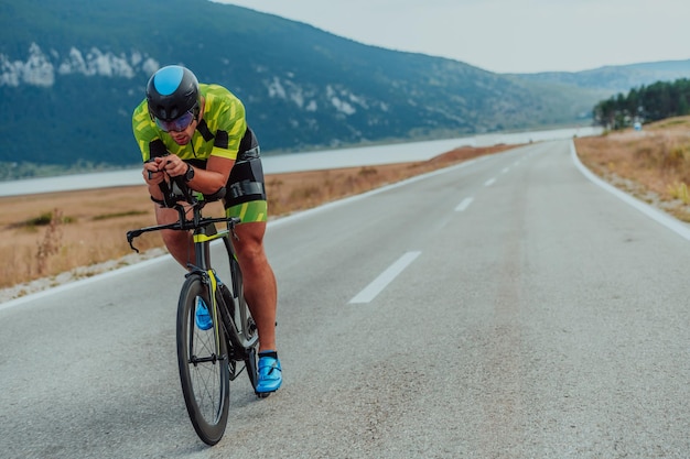 Foto ganzkörperporträt eines aktiven triathleten in sportbekleidung und mit schutzhelm auf dem fahrrad. selektiver fokus.