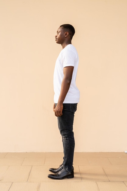 Ganzkörperporträt eines gutaussehenden afrikanischen Mannes mit weißem T-Shirt