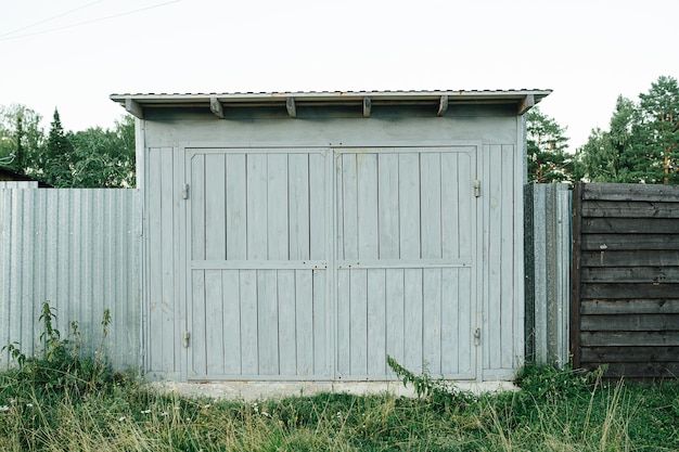 Garagem de carro rústica feita de tábuas e armação de metal bem pintada