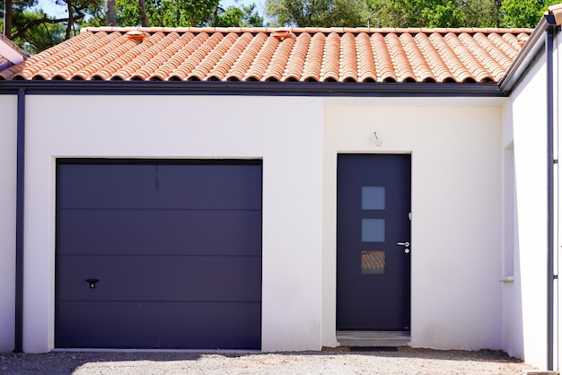 Garagem doméstica da fachada de entrada seccional da nova casa de construção moderna na vista da rua do subúrbio