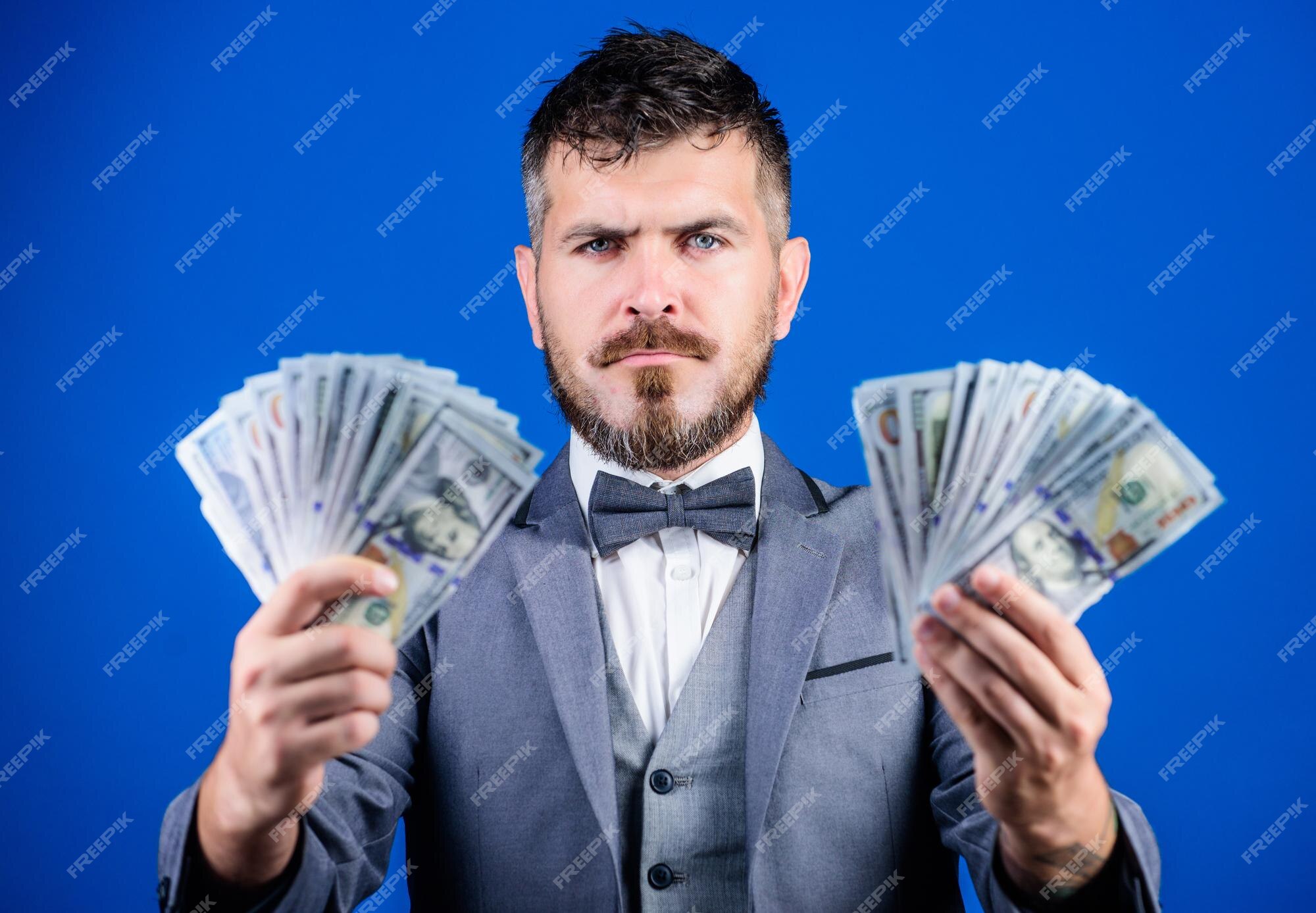 Empréstimo de dinheiro fácil homem terno formal segura muitas notas de  dólar fundo azul empresário tem dinheiro pegue meu dinheiro ganhe dinheiro  real conceito de riqueza e bem-estar negócios de transações em