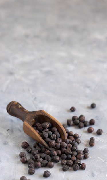 Garbanzo negro seco de Apulia y Basilicata en Italia en la pala de madera sobre mesa gris con espacio de copia, primer plano