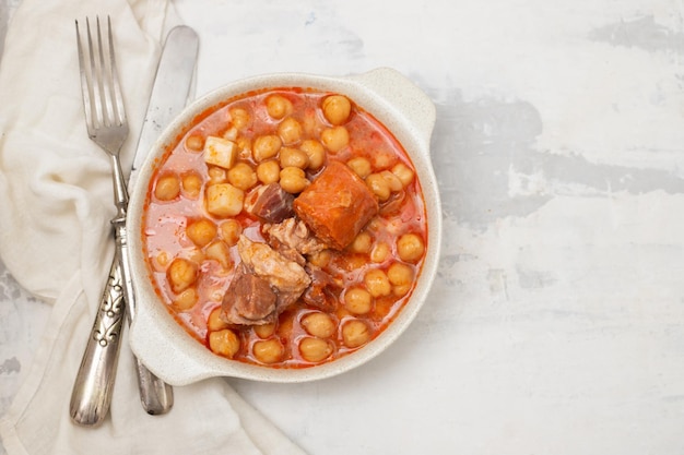 Garbanzo con salchichas ahumadas en tazón blanco