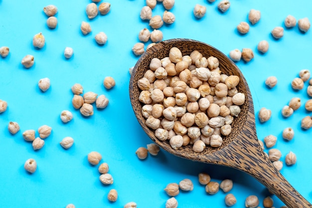 Garbanzos en cuchara de madera en azul