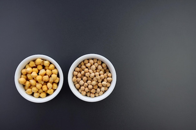 Garbanzos empapados de agua y garbanzos secos en un recipiente redondo sobre un fondo gris