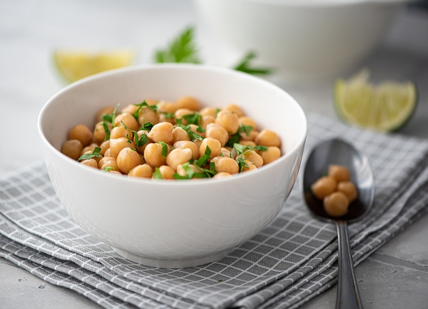 Foto garbanzos hervidos con hierbas y aceite de oliva en un tazón blanco