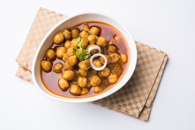 Garbanzos Masala - Chole masala o choley curry, almuerzo tradicional del norte de la India, menú de cena servido en un cuenco de cerámica, enfoque selectivo