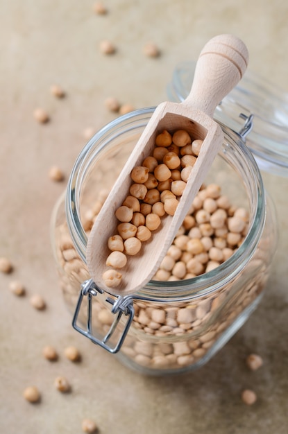 Foto garbanzos orgánicos crudos en un frasco de vidrio, ingrediente de comida vegetariana vegana saludable.