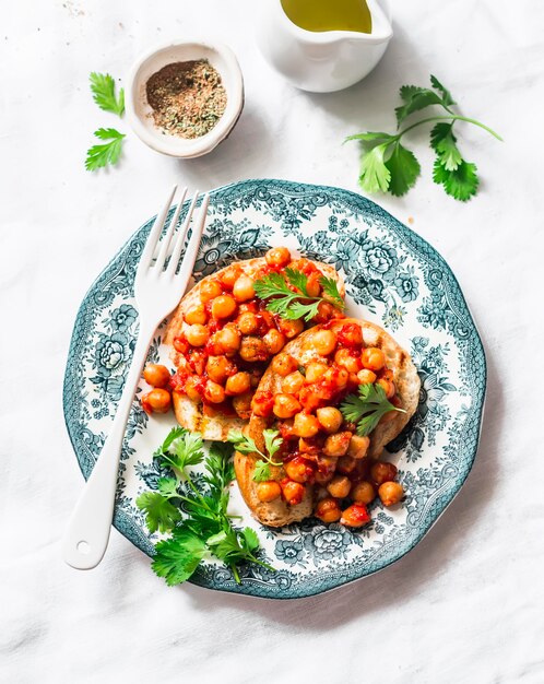 Garbanzos picantes en salsa de tomate tostadas deliciosas meriendas en una vista superior de fondo claro