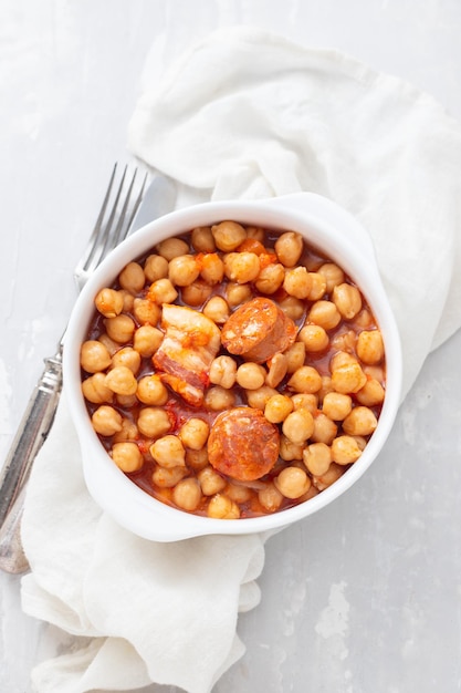 Garbanzos con salchicha ahumada en tazón de fuente blanco