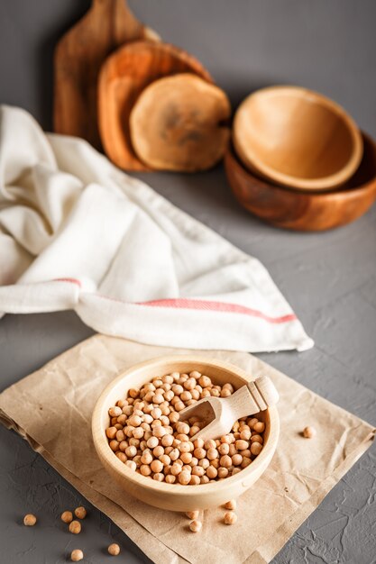 Garbanzos en un tazón de madera sobre fondo gris