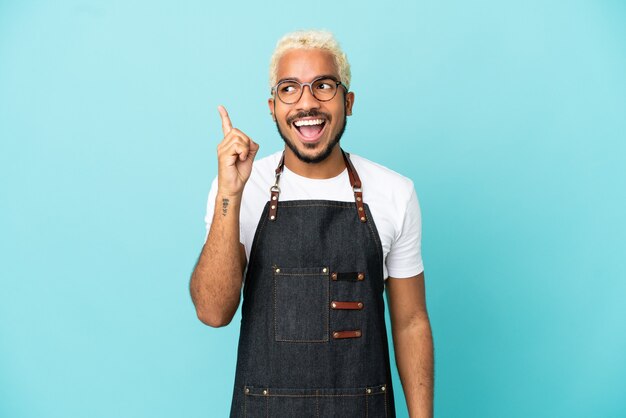 Garçom colombiano do restaurante isolado em um fundo azul com a intenção de descobrir a solução enquanto levanta um dedo