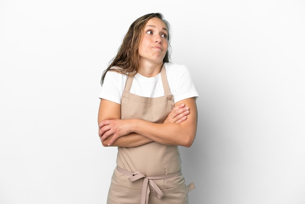 Garçom de restaurante, mulher caucasiana isolada no fundo branco fazendo gestos de dúvida enquanto levanta os ombros