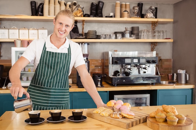 Garçom, derramando café em uma xícara