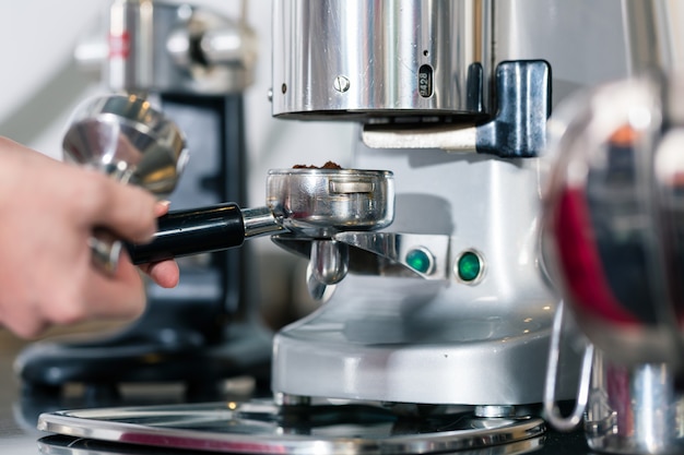 Garçom preparando café expresso em uma máquina de café automática