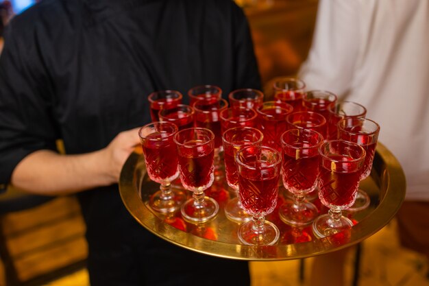 Garçom segurando uma bandeja com um coquetel de aperol spritz