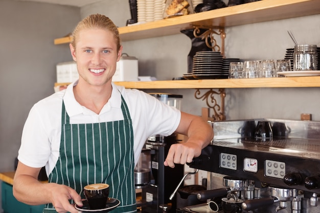 Garçom, segurando uma xícara de café