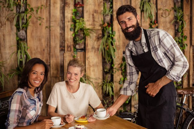 Foto garçom servindo cafés