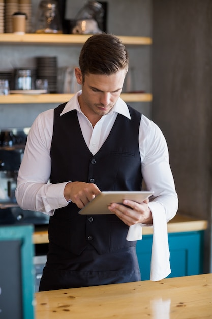 Garçom, usando tablet digital no restaurante