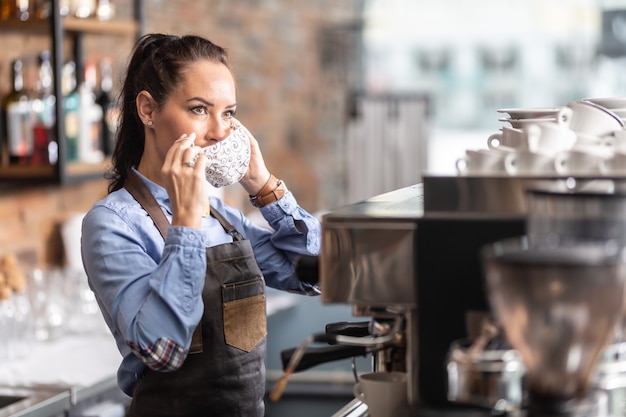 Garçonete coloca máscara facial em um café devido a medidas tomadas pelo governo para limitar a propagação do coronavírus.