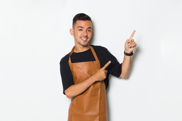 Garçonete de barista jovem feliz apontando para diferentes direções