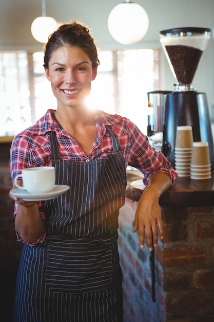 Garçonete, segurando uma xícara de café