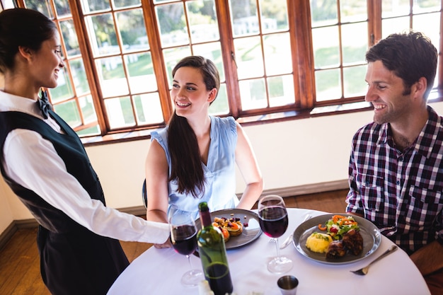 Garçonete, servindo, prato comida, tabela clientes