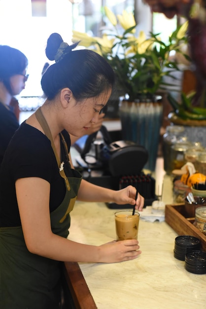 Garçonete vietnamita preparando café em uma cafeteria