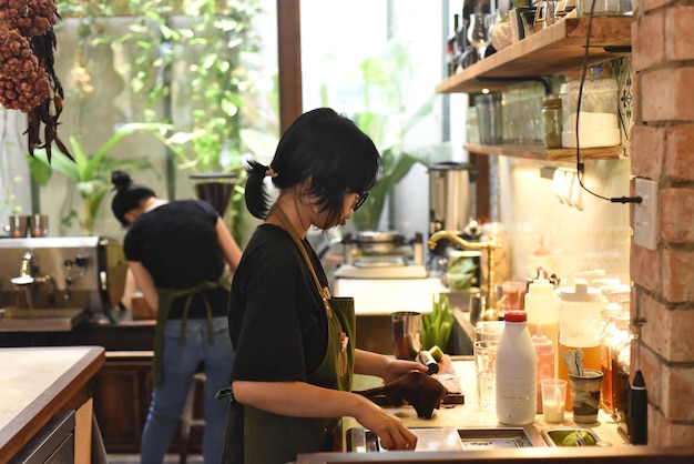 Garçonete vietnamita preparando um pedido em uma cafeteria