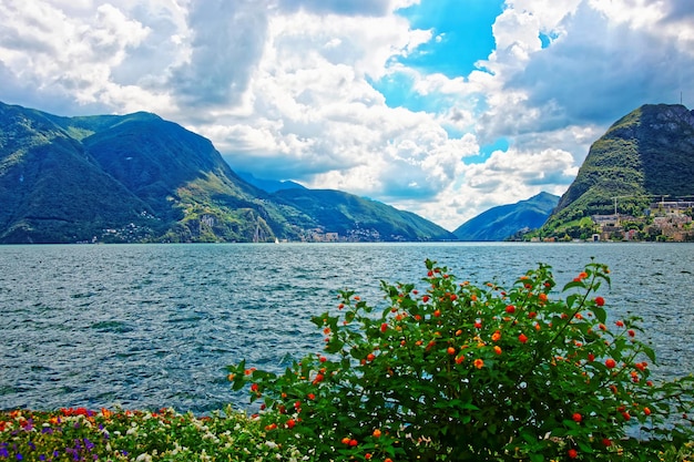 Garden Park en el paseo marítimo del lujoso resort en Lugano en el lago Lugano y las montañas de los Alpes en el cantón de Ticino Suiza.