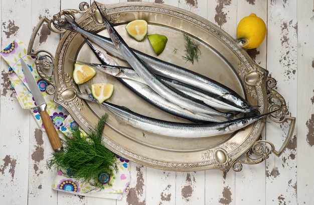 Garfish, billfish crudo y fresco, vista superior, con cebolla, limón, preparado para cocinar