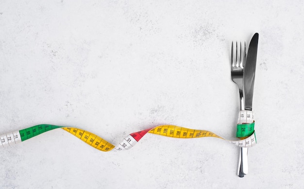 Foto garfo apertado com uma fita métrica, copie o espaço para texto, fazendo dieta, perdendo peso, ficando com fome