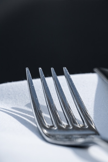 Foto garfo e faca com guardanapo branco na mesa em restaurante de luxo ao ar livre, menu de jantar fino para casamento ...