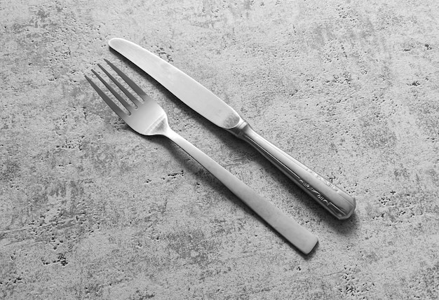 Foto garfo e faca de prata em um fundo cinza