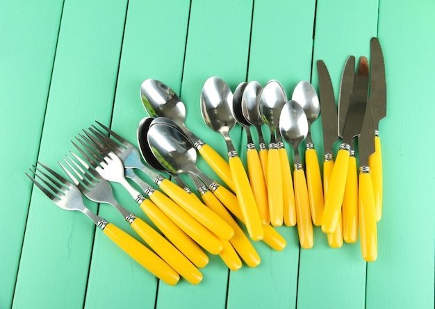 Foto garfos, facas, colheres, em, cor, fundo madeira