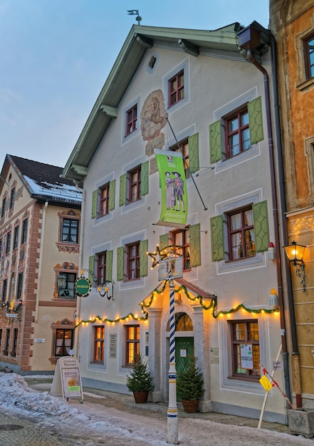 Garmisch-Partenkirchen, Deutschland - 6. Januar 2015: Äußeres des bezaubernden Hauses im bayerischen Stil in Garmisch-Partenkirchen mit grünen Fensterläden, schöner Fassadenmalerei und Weihnachtsdekoration