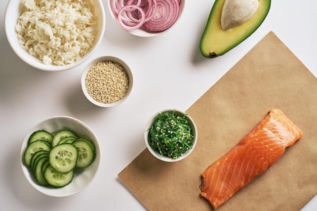 Garnelenlachs-Stoßschüssel auf Kraftpapier, Chuka-Salat, weißem Reis, Gurke