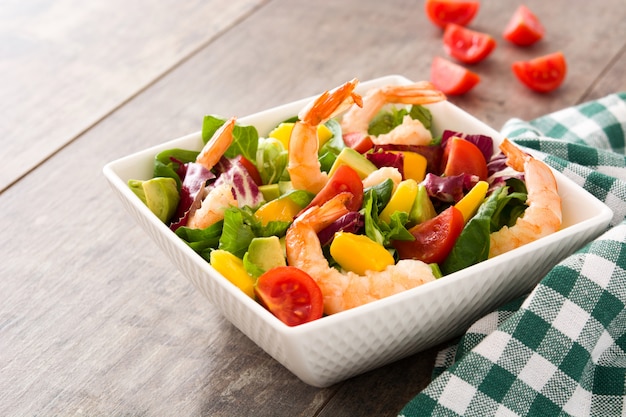 Garnelensalat mit Mango und Avocado auf Holztisch