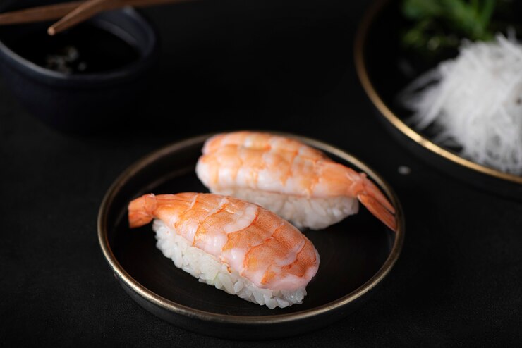 Foto garnelensushi auf einem schwarzen tisch