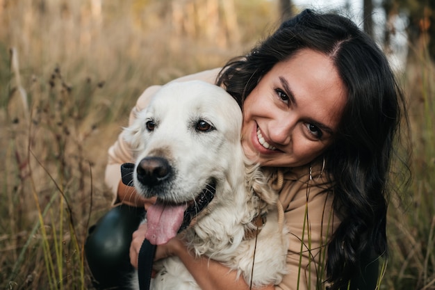 Foto garota abraçando um cachorro golden retriever no campo